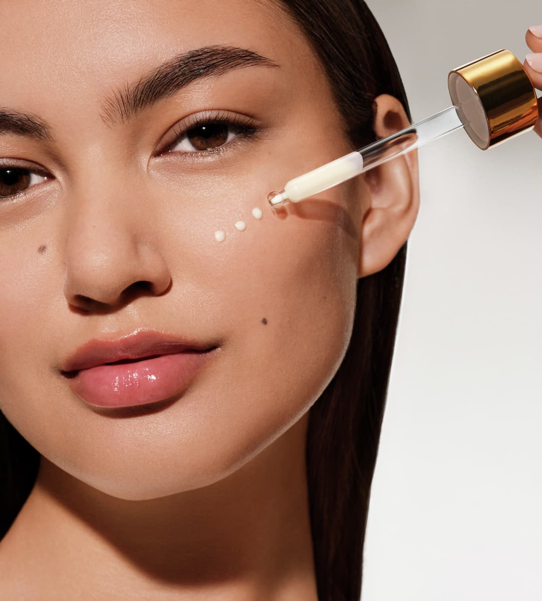 Woman applying serum on her face