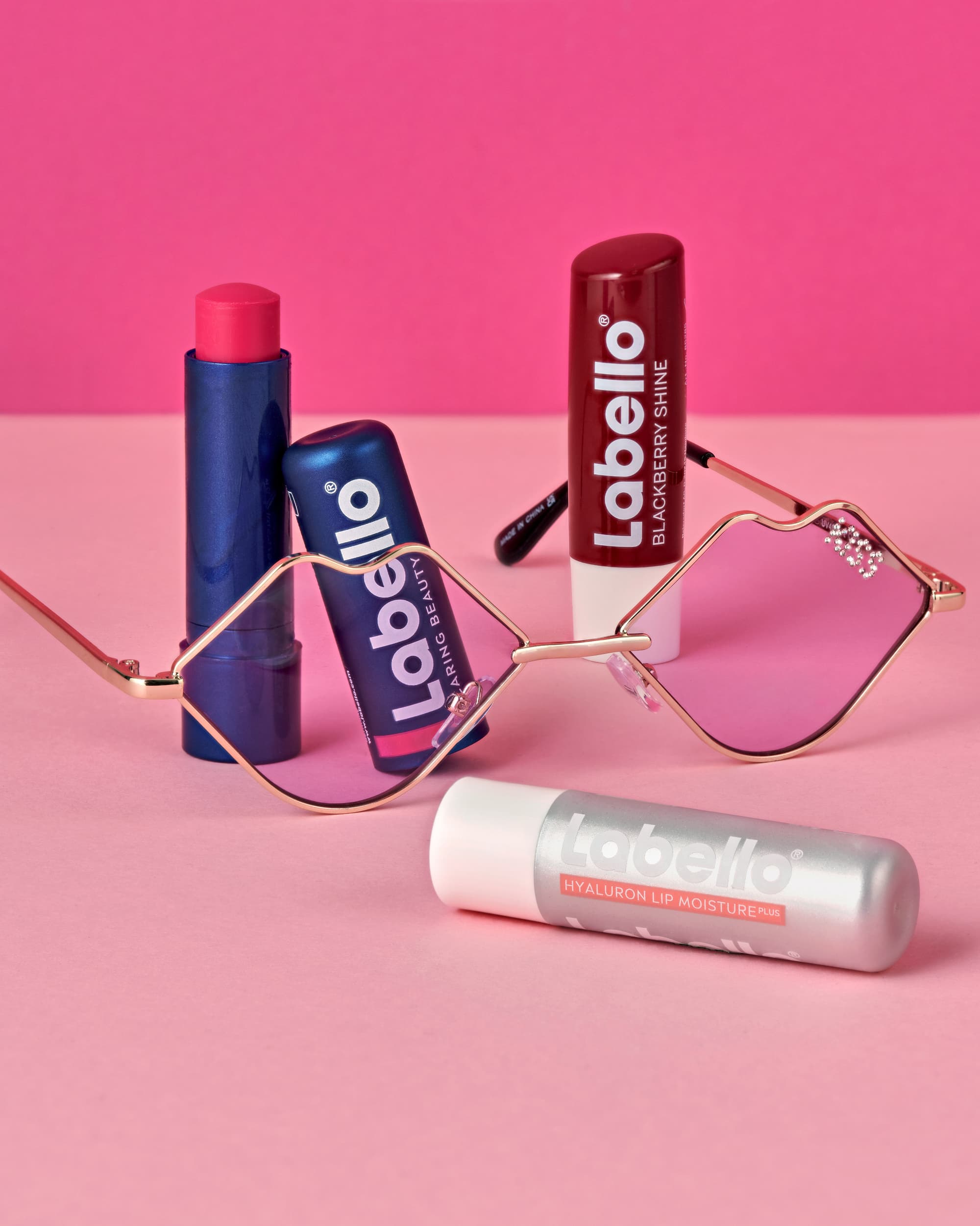 Lip balms on pink background