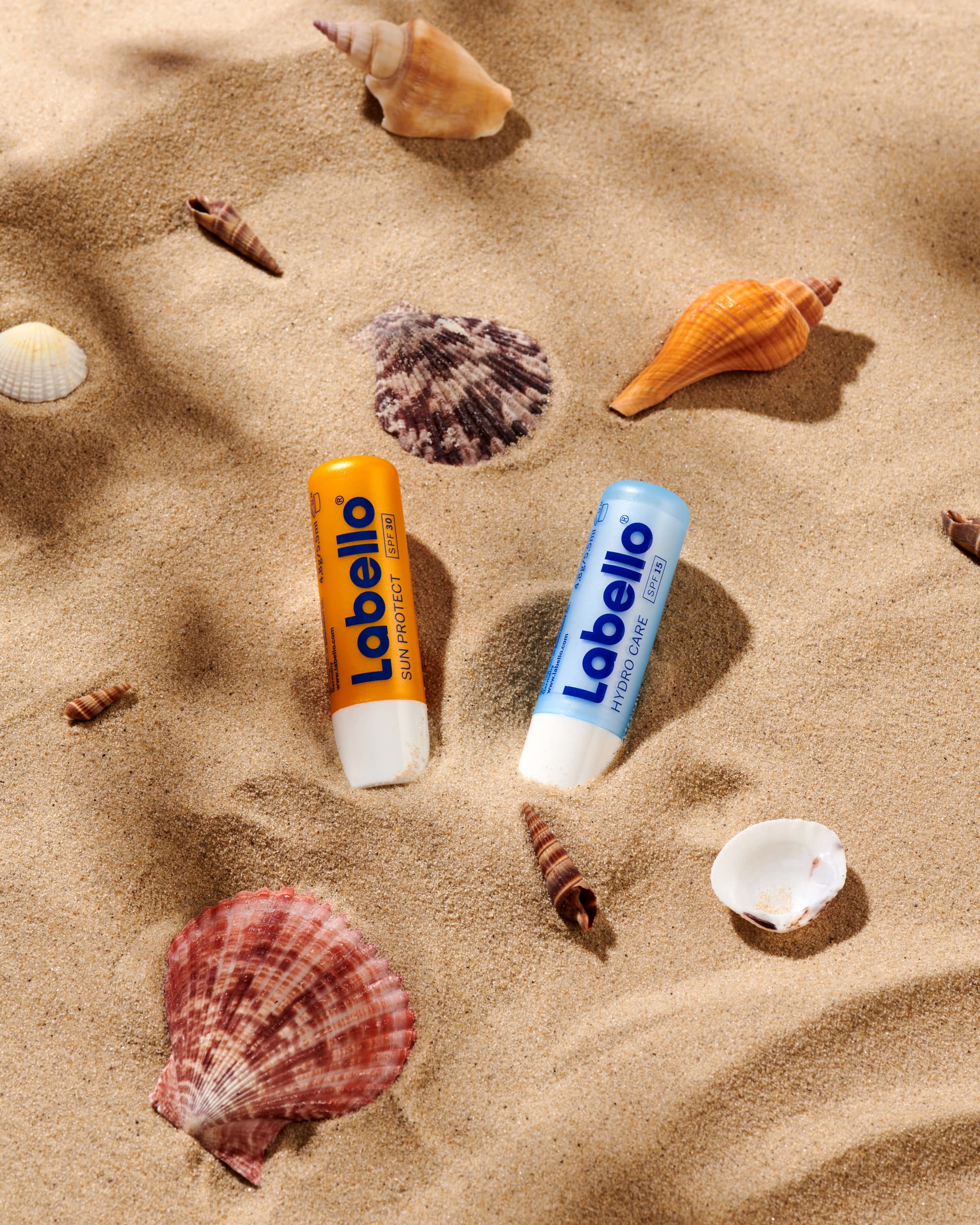 Two lip balms in the sand