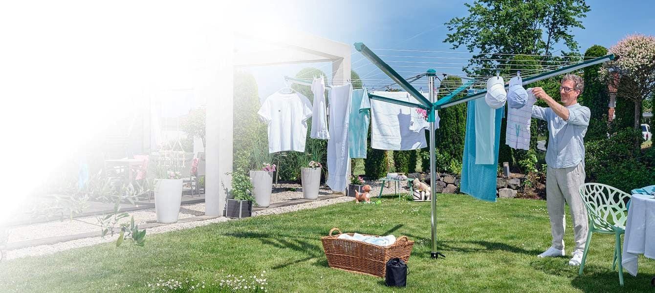 Man hanging clothes on drying rack in the garden