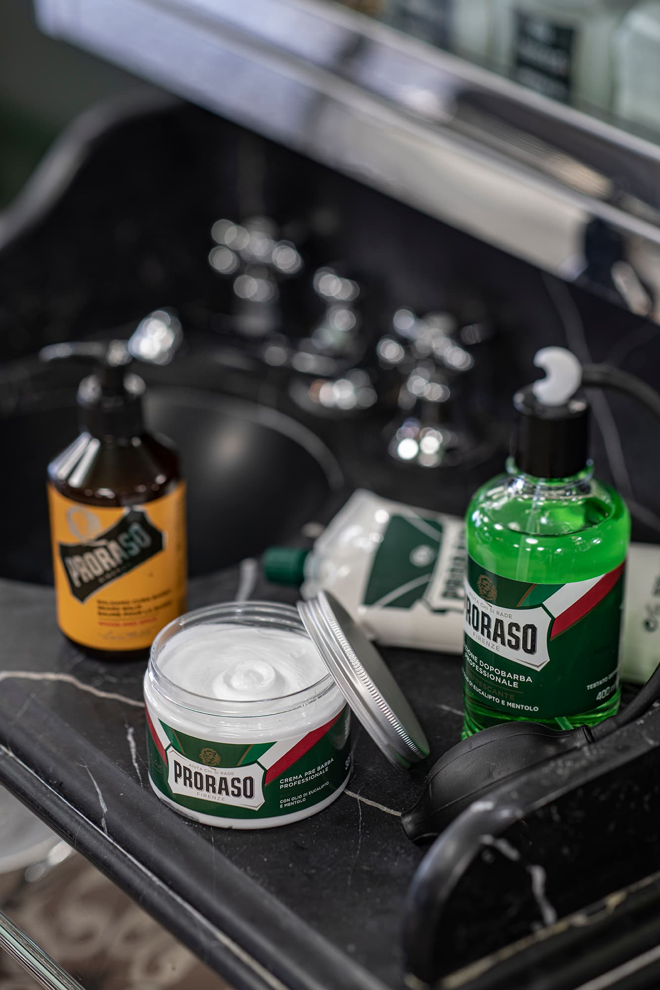 3 grooming products on a black sink