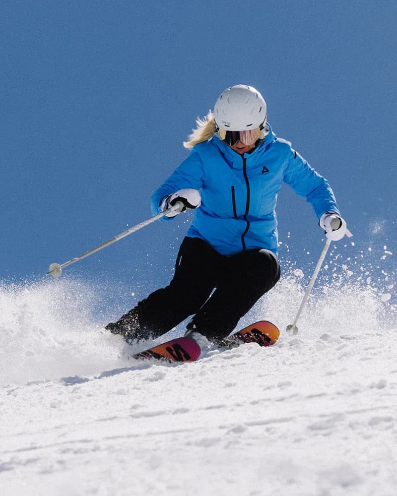 Woman in blue jacket skiing